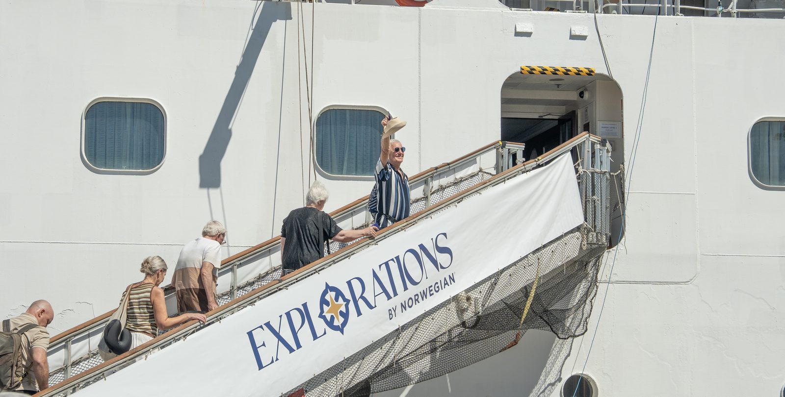 A guest waving his hat from the gangway