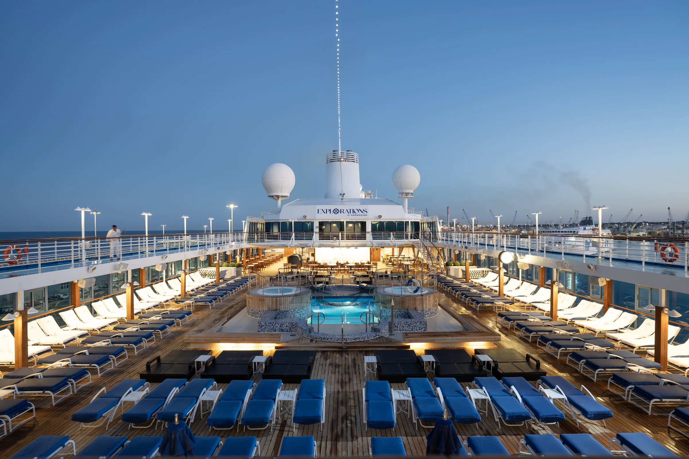 The pool deck of Explorations by Norwegian at blue hour